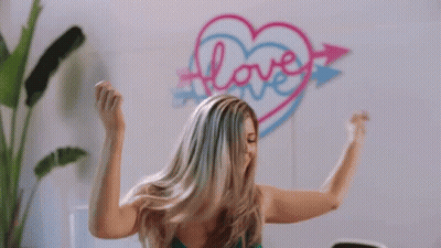 Woman Flexing Muscles By Heart Wall With Love GIF