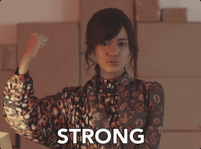 Woman Flexing Muscles In Front Of Strong Sign GIF