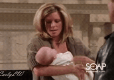 Woman Holding Baby Next To Man GIF