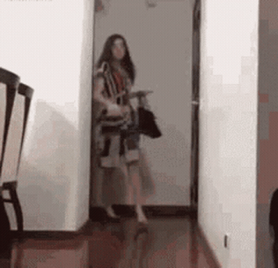 Woman Holding Bag And Purse In Hallway GIF