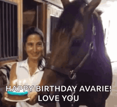 Woman Holding Birthday Cake In Front Of Horse In Barn GIF