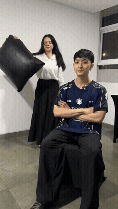 Woman Holding Black Pillow In Front Of Man In TFSG Shirt GIF