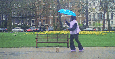 Woman Holding Blue Umbrella In Rain GIF