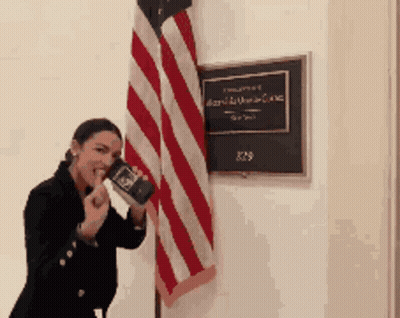 Woman Holding Book Beside American Flag GIF