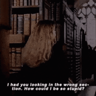Woman Holding Book In Front Of Bookshelf GIF