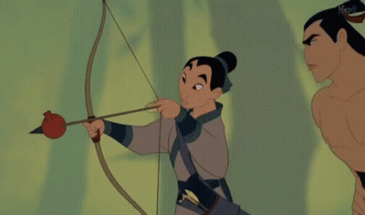 Woman Holding Bow And Arrow Next To Shirtless Man GIF