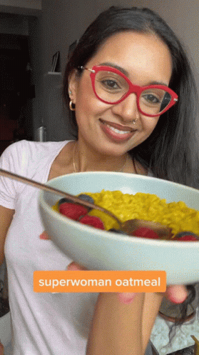 Woman Holding Bowl Of Superwoman Oatmeal With Strawberries And Blueberries GIF