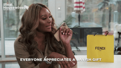 Woman Holding Cell Phone Next To Yellow Bag Saying Fendi GIF