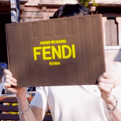 Woman Holding Cell Phone Next To Yellow Fendi Bag GIF