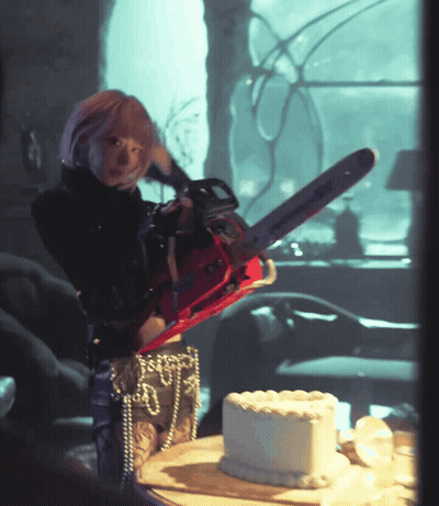 Woman Holding Chainsaw Over Cake GIF