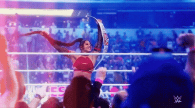 Woman Holding Championship Belt In Wrestling Ring With Crowd GIF