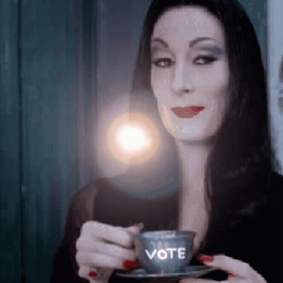 Woman Holding Coffee Cup Saying Vote GIF