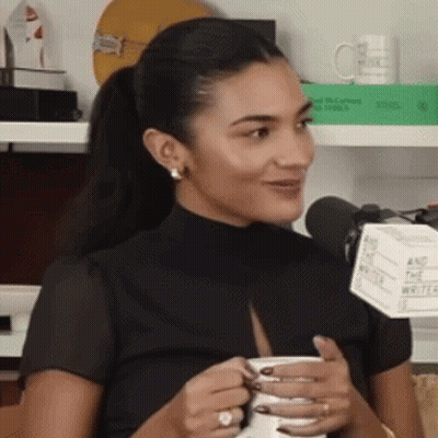 Woman Holding Coffee Smiling Into Microphone GIF