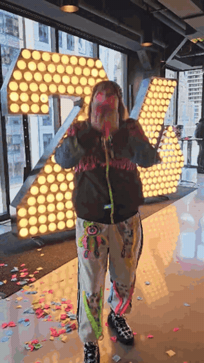 Woman Holding Confetti Cannon By Large Letter R GIF