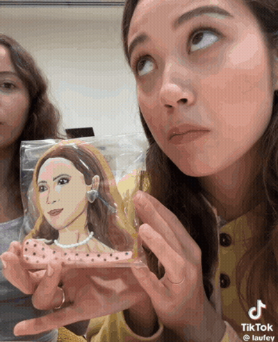 Woman Holding Cookie With Woman Drawing GIF