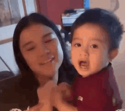 Woman Holding Crying Baby Smiling GIF