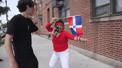 Woman Holding Flag And Microphone Interviewed By Man GIF
