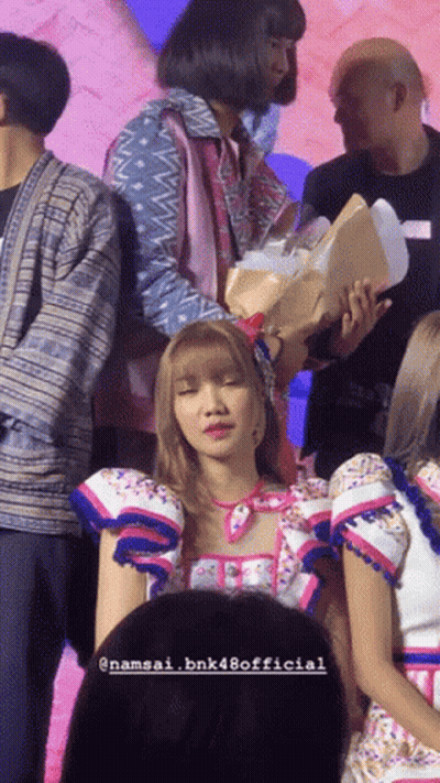Woman Holding Flowers Surrounded By People Namsai Bnk48 Official GIF