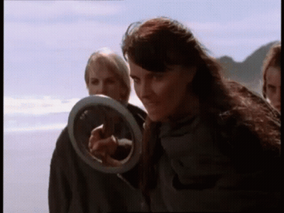 Woman Holding Frisbee Pointing On Beach GIF