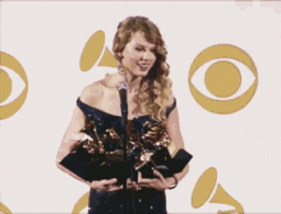 Woman Holding Grammy Award At Microphone GIF