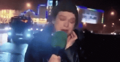 Woman Holding Green Object In Front Of Face GIF
