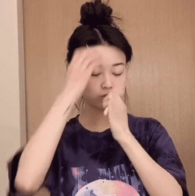 Woman Holding Hair Bun Applying Makeup GIF