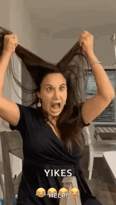 Woman Holding Hair In Air With Mouth Open GIF