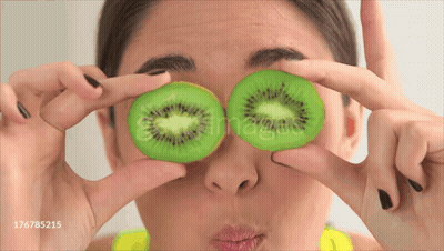 Woman Holding Kiwi Slices GIF