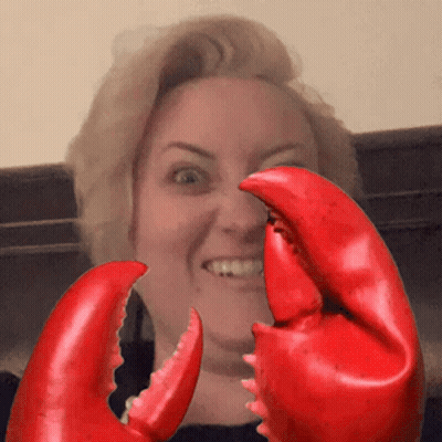 Woman Holding Large Red Lobster Claws In Front Of Face GIF