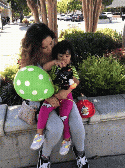 Woman Holding Little Girl And Green Polka Dot Balloon GIF