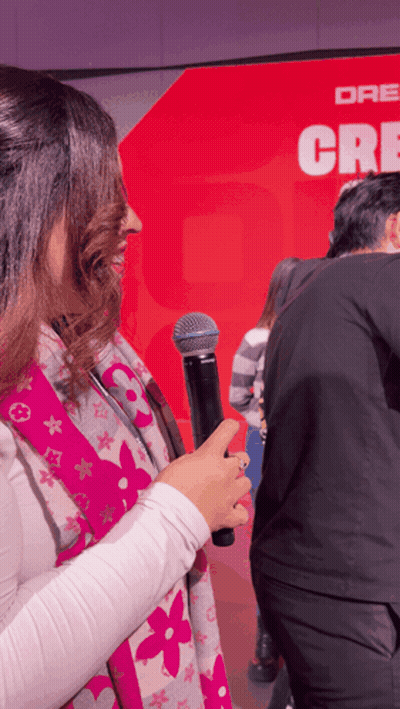 Woman Holding Microphone Before Red Wall Dr. Cre GIF
