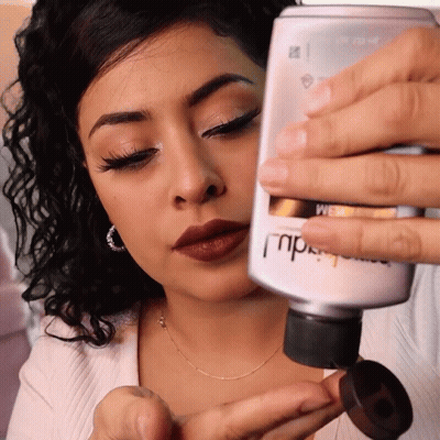 Woman Holding MPD Lotion Bottle GIF