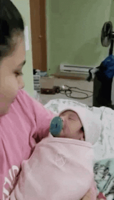 Woman Holding Newborn Baby With Pacifier GIF