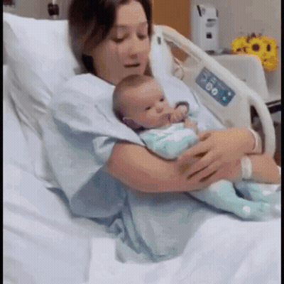 Woman Holding Newborn In Hospital Bed GIF