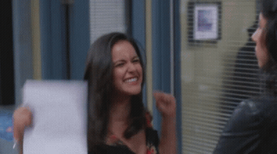 Woman Holding Paper Smiling While Another Laughs GIF