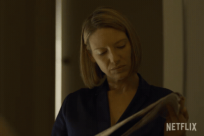 Woman Holding Paper With Netflix Logo GIF