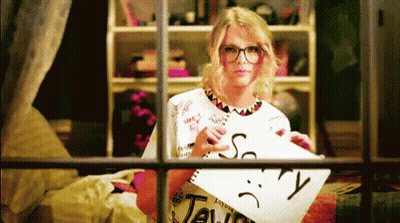 Woman Holding Paper With Sad Face And Word Taylor GIF