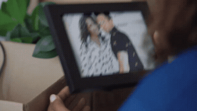 Woman Holding Picture Of Man And Woman GIF