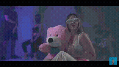 Woman Holding Pink Teddy Bear In Front Of Crowd GIF