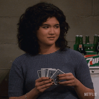 Woman Holding Playing Cards in Front of 7Up Bottle