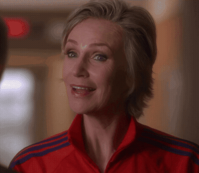 Woman Holding Red Fire Extinguisher In Front Of Trophies GIF
