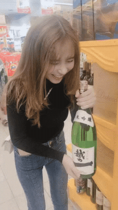 Woman Holding Sake Bottle With Chinese Characters GIF