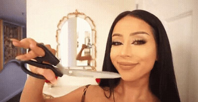 Mujer sosteniendo tijeras cerca de la cara GIF