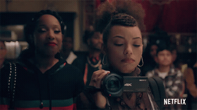 Woman Holding Sony 4K Camera In Front Of Crowd GIF