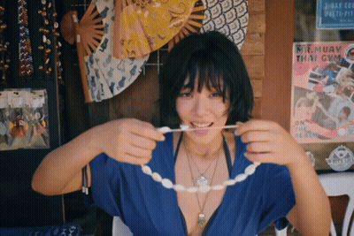 Woman Holding String In Mouth In Front Of Mik Muay Thai Gym Poster GIF