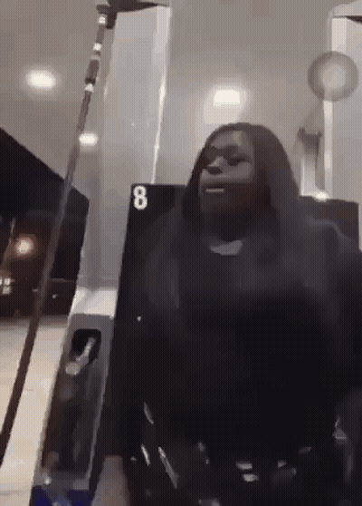 Woman Holding Sword At Gas Station GIF