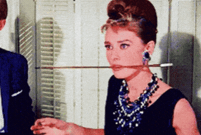 Woman Holding Sword In Mouth With Necklace And Earrings GIF