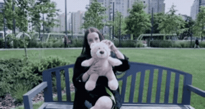 Woman Holding Teddy Bear On Park Bench GIF