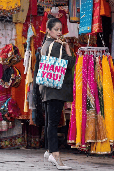 Woman Holding Thank You Bag In Front Of Store GIF