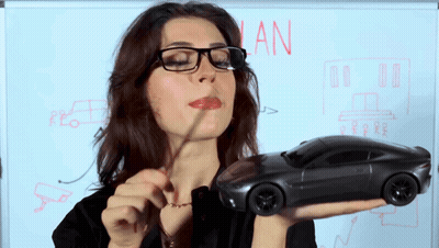 Woman Holding Toy Car In Front Of Whiteboard Saying Plan GIF